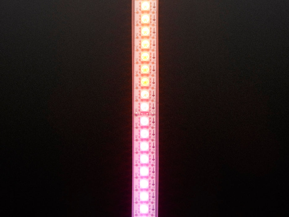 Shot of lightly coiled LED strip glowing rainbow colors.