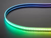 Shot of lightly coiled LED strip glowing rainbow colors.