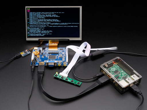 Front shot of a HDMI 4 Pi: 7" Display connected to a Raspberry Pi. The monitor displays a desktop background with a adafruit logo, raspberry logo, and a heart. 