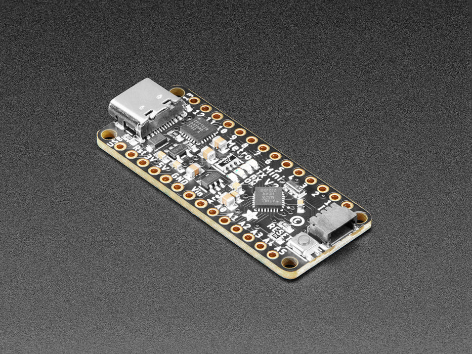 Overhead shot of long skinny black microcontroller connected to an OLED screen and a temperature-and-humidity sensor. The sensor data displays on the OLED.