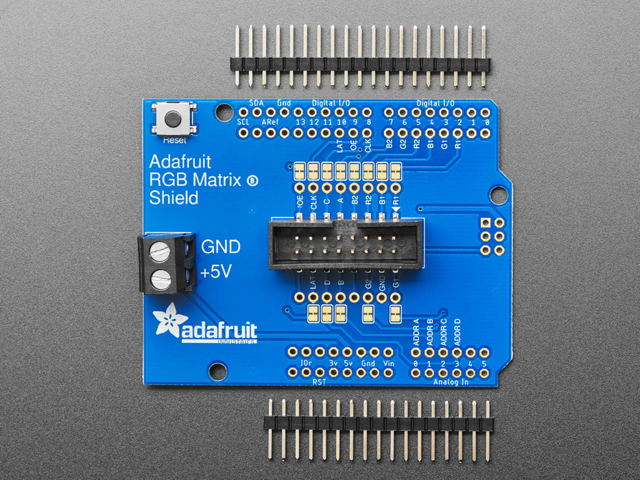 Adafruit RGB Matrix Shield for Arduino connected to a LED Matrix that reads "Adafruit Industries LED MATIX! 32x64 *RGB*"