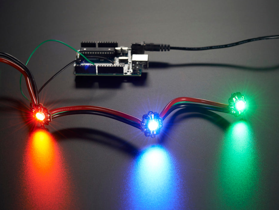 Animation of three very bright chained LEDs all changing rainbow colors