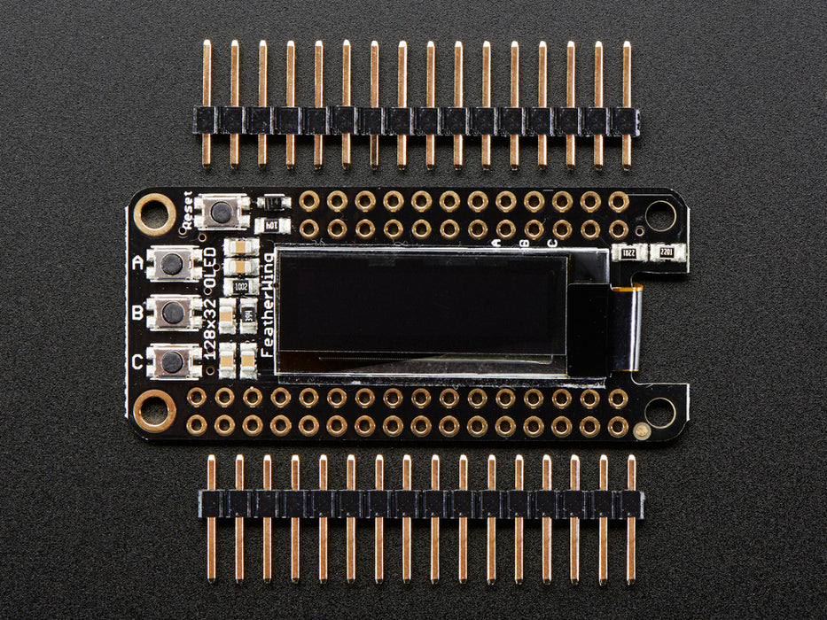 Angled shot of a Adafruit FeatherWing OLED - 128x32 OLED Add-on For Feather connected to a white breadboard and a lithium battery. 