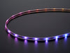 Adafruit NeoPixel Digital RGB LED Strip wired with all the LEDs illuminating various colors. 