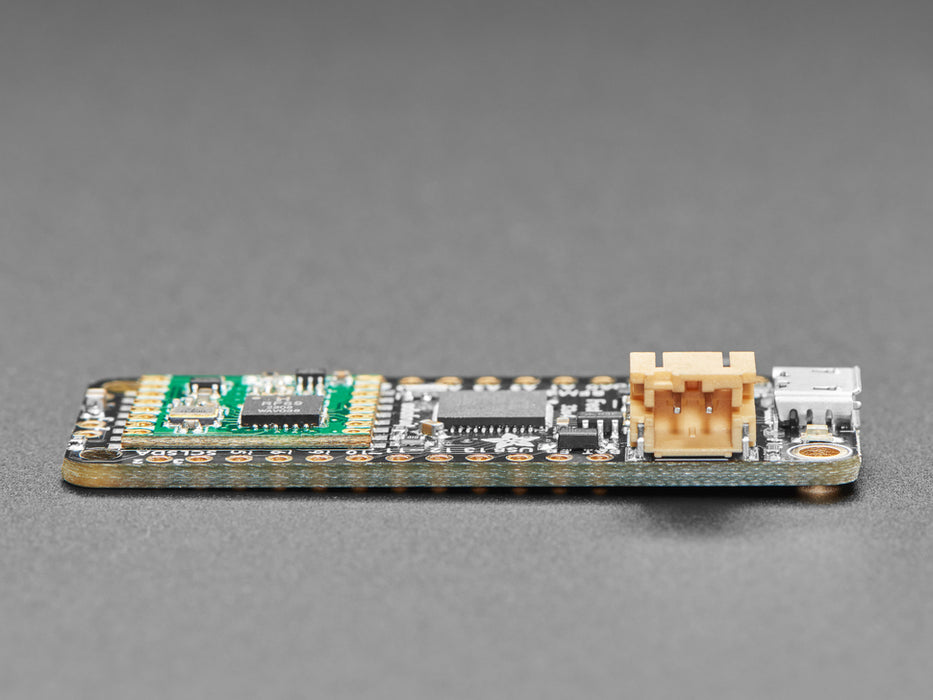 Angled shot of a rectangular microcontroller connected to a white breadboard and a lithium battery. 