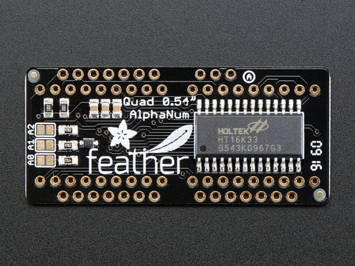 Angled shot of a rectangular shaped Quad Alphanumeric Display breakout board with an LED matrix soldered on.