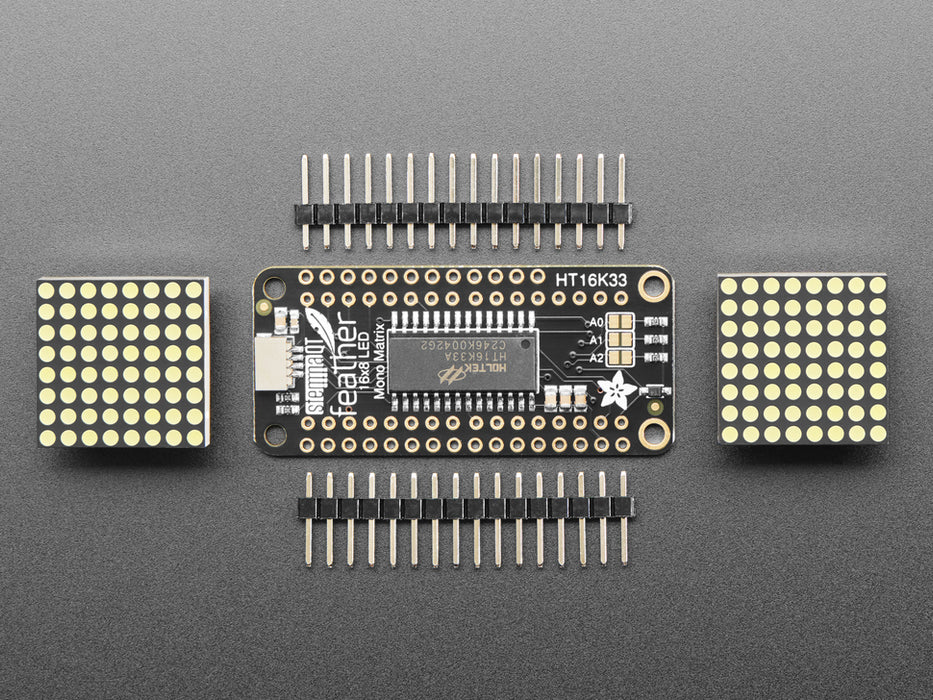 Angled shot of a rectangular shaped LED Matrix FeatherWing Display Kit breakout board with an LED matrix soldered on.