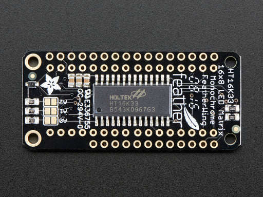 Angled shot of a rectangular shaped LED Matrix FeatherWing Display Kit breakout board with an LED matrix soldered on.