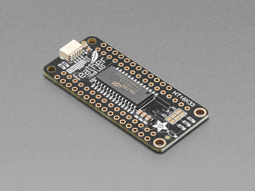 Angled shot of a rectangular shaped LED Matrix FeatherWing Display Kit breakout board with an LED matrix soldered on.