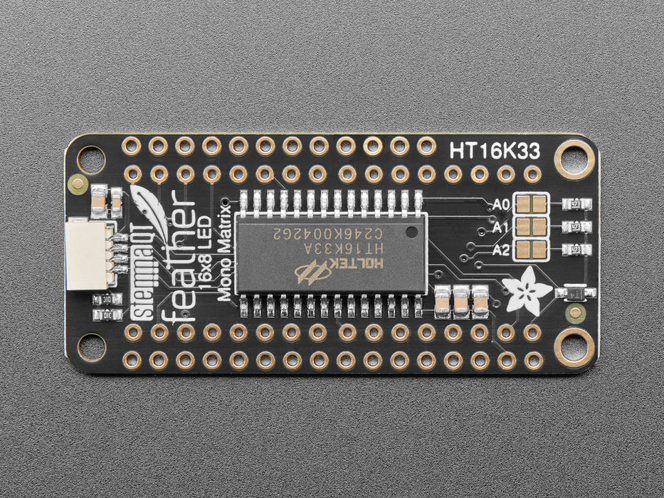 Angled shot of a rectangular shaped LED Matrix FeatherWing Display Kit breakout board with an LED matrix soldered on.