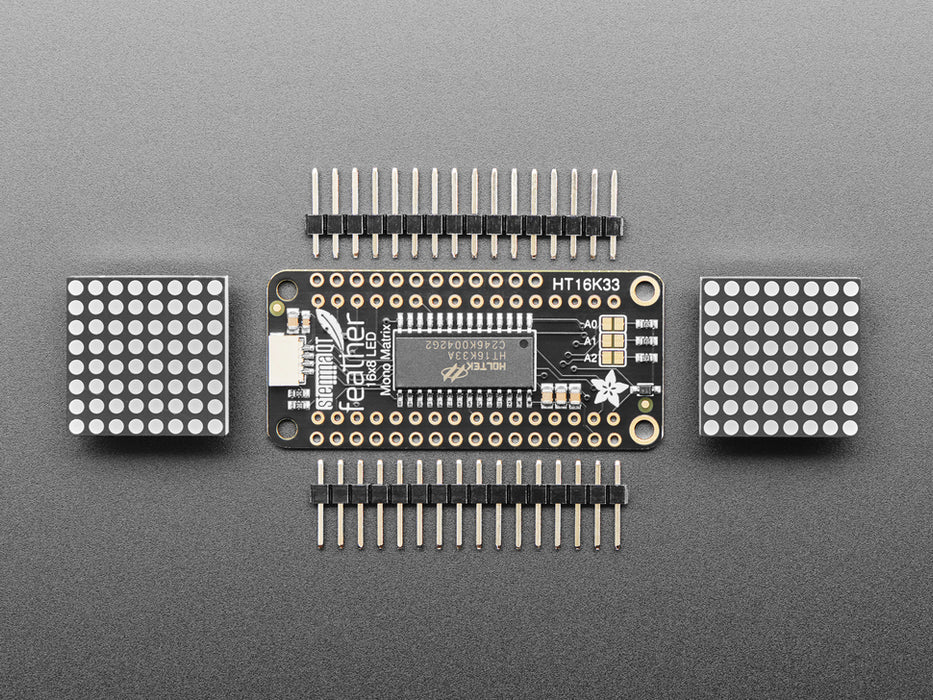 Angled shot of a rectangular shaped LED Matrix FeatherWing Display Kit breakout board with an LED matrix soldered on.