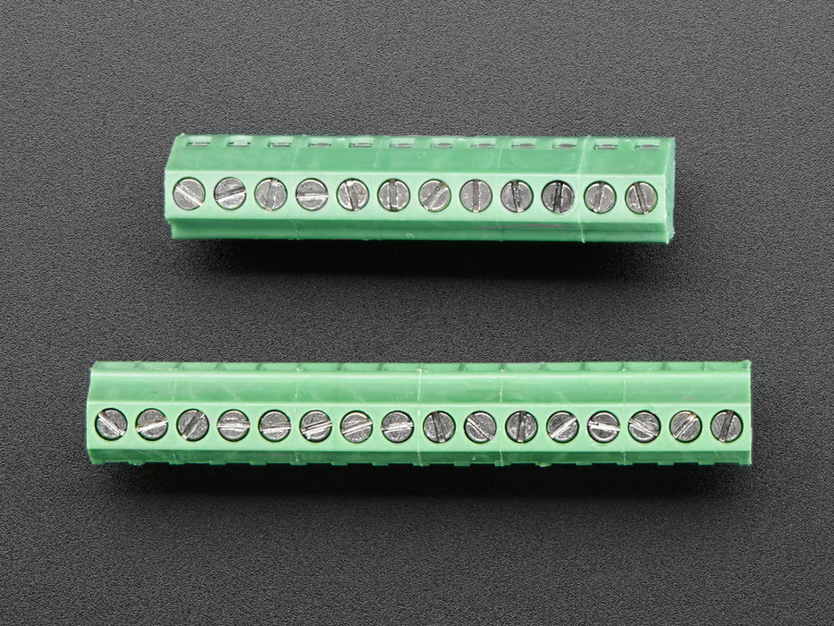 Angled shot of two Terminal Blocks kit for Feather - 0.1" Pitch assembled on an Adafruit Feather board.