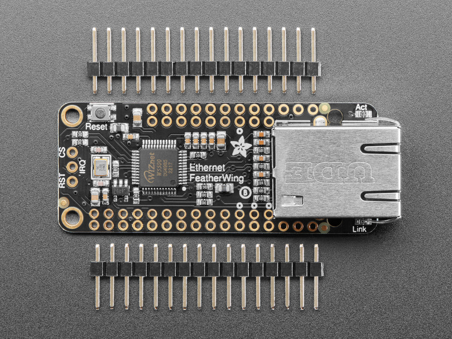 Angled shot of a Adafruit Ethernet FeatherWing with an Ethernet cable connected to it. 