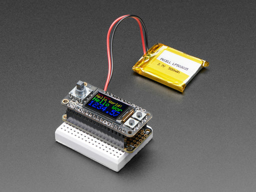 Angled shot of a Adafruit Mini Color TFT with Joystick FeatherWing on a small white breadboard connected to a lithium battery. 