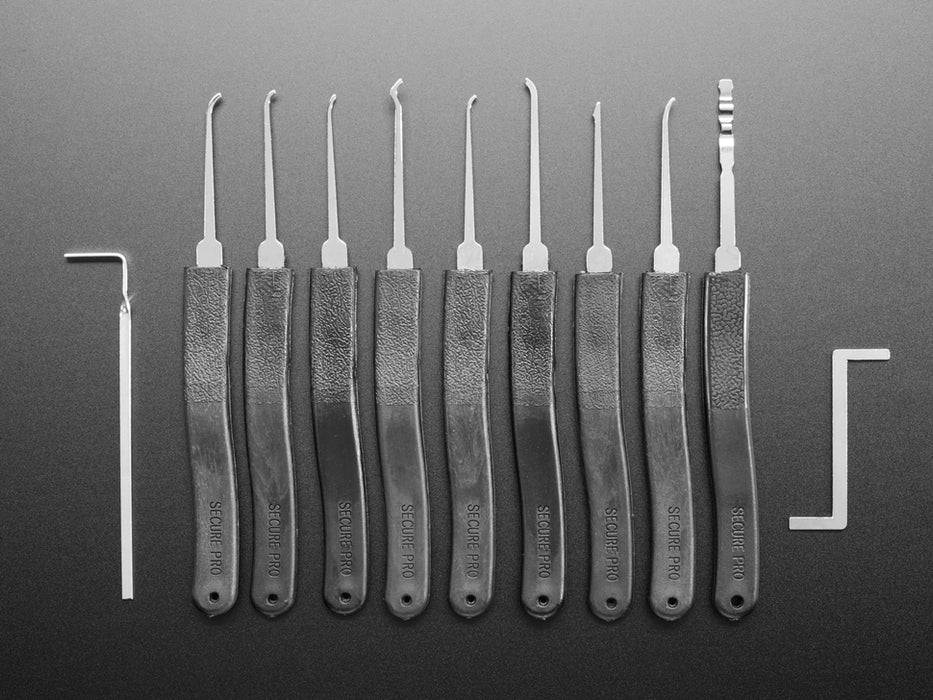 Array of many lock picks with plastic handles, plus wrenches