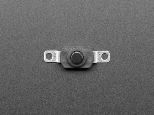 Angled shot of black mini on/off pushbutton switch with two mounting holes.