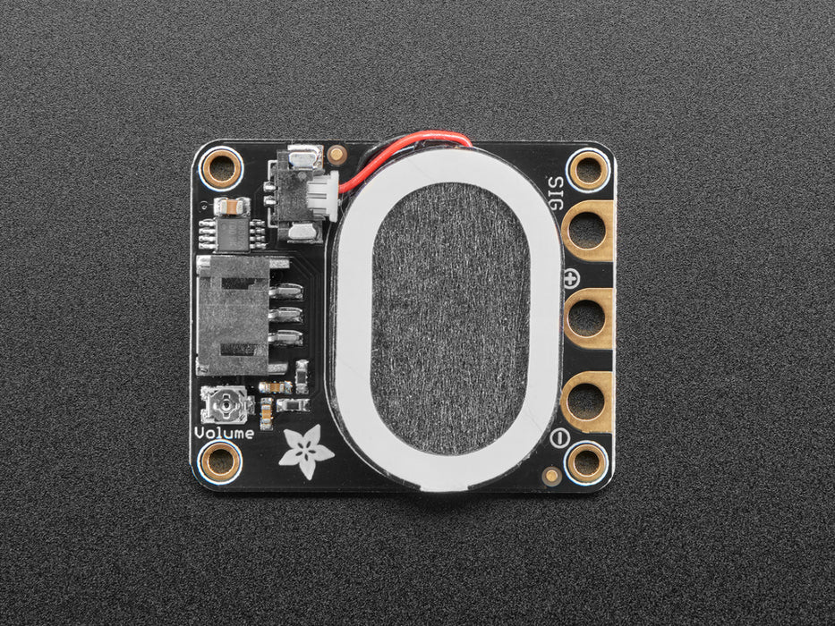 Top view of a black speaker breakout board connected to a round microcontroller via alligator clips. A music note animation emits from the speaker.