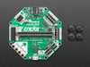 Angled shot of a Adafruit CRICKIT for micro:bit connected to a black squared board.