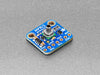 Angled shot of small, blue square-shaped pressure sensor breakout board.