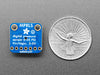 Angled shot of small, blue square-shaped pressure sensor breakout board.