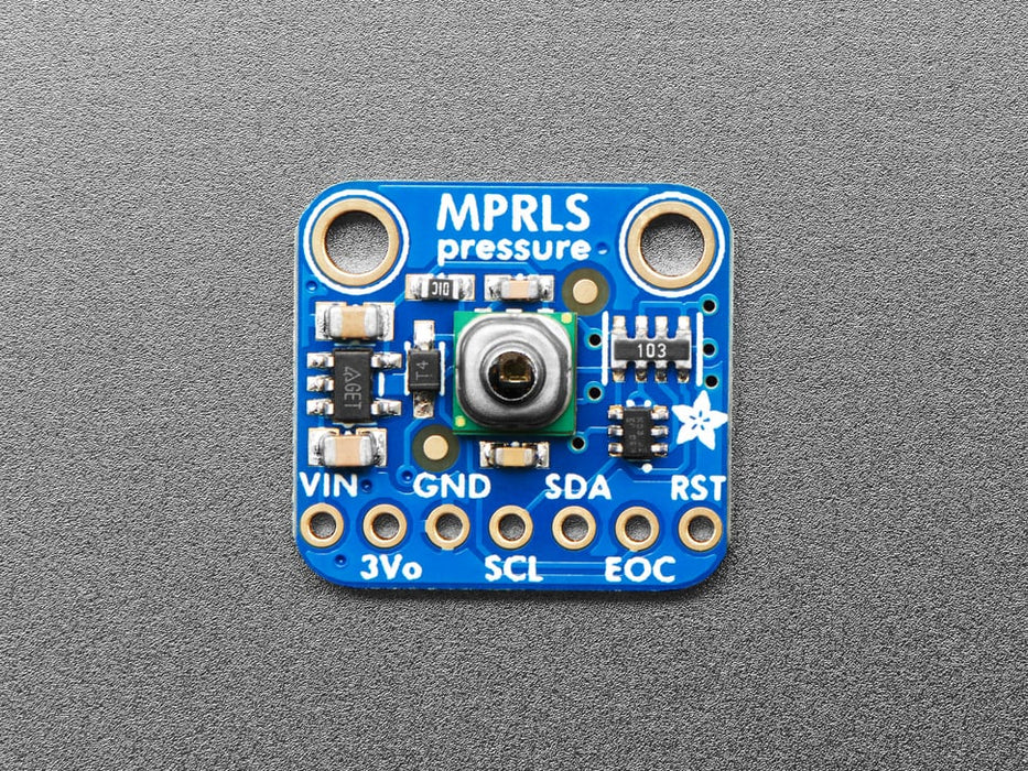 Angled shot of small, blue square-shaped pressure sensor breakout board.