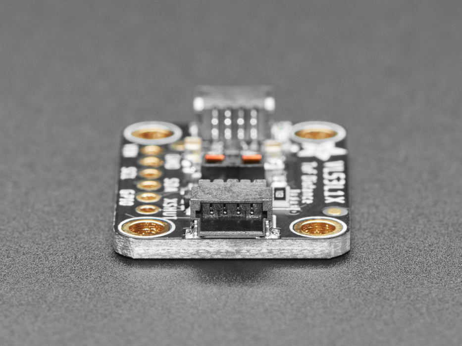 Top view of Adafruit VL53L1X Time of Flight Distance Sensor hooked up to an OLED display. A white manicured hand waves at the sensor, and the OLED displays the distance.