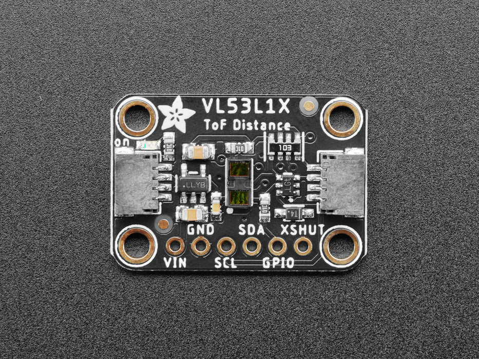 Top view of Adafruit VL53L1X Time of Flight Distance Sensor hooked up to an OLED display. A white manicured hand waves at the sensor, and the OLED displays the distance.