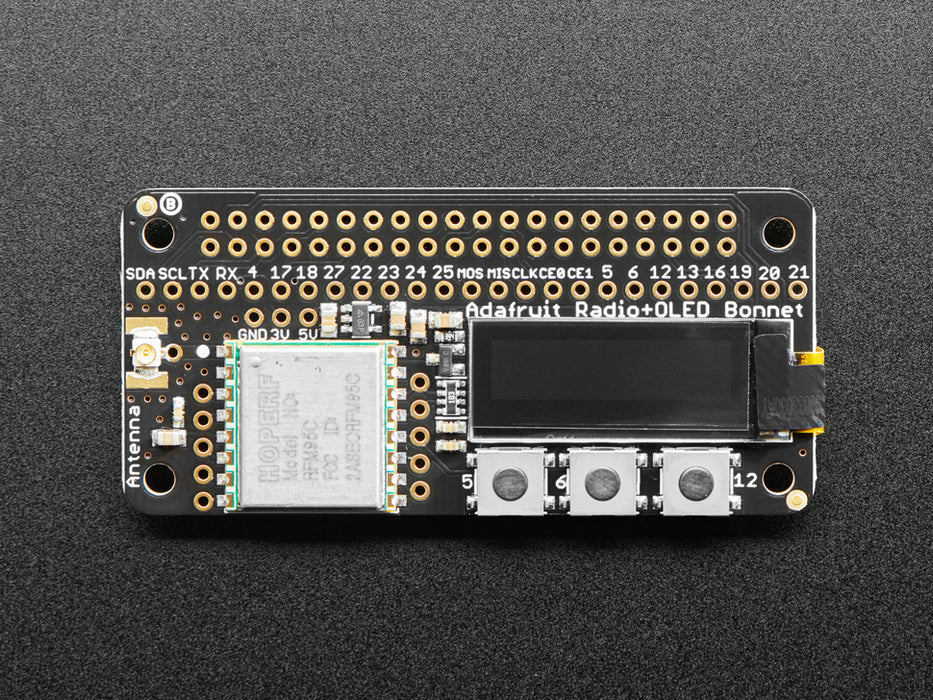 A rectangular microcontroller with OLED screen. A blue-manicured index finger presses buttons below the OLED screen, triggering different texts.