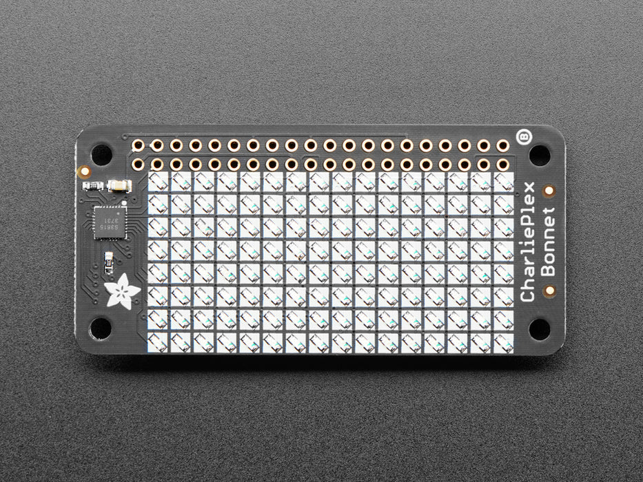 Top down view of a Adafruit CharliePlex LED Matrix Bonnet illuminating green. 