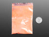 Angled shot of plastic baggy containing orange thermochromic pigment powder.