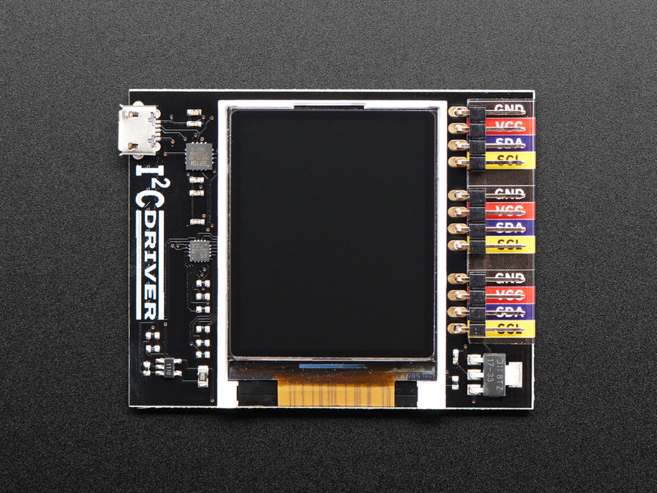 Top down view of a  I2CDriver by Excamera Labs attached to a small blue squared breakout board being held by a white hand. 