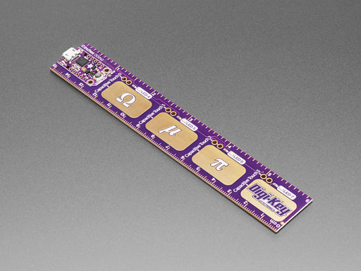 A purple-manicured finger presses the capacitive touch pads on a purple electronic ruler. The LEDs light up as the finger presses the capacitive gold pad.