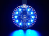 shot of a Black woman's neon-green manicured hand holding up a Circuit Playground Bluefruit glowing rainbow LEDs.