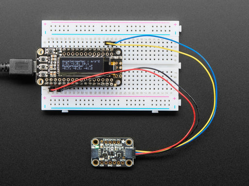 Video of a white hand moving a Adafruit LSM303AGR Accelerometer Magnetometer around and a OLED connected to a white breadboard. 