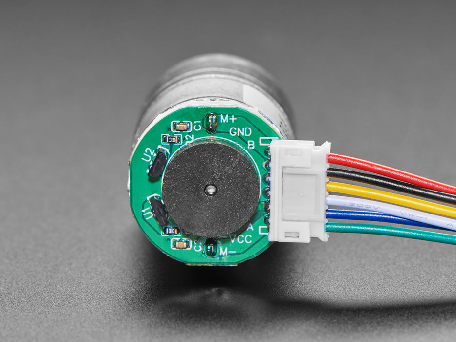 Angled view of a Geared DC Motor rotating while connected Circuitry shows RPM changing