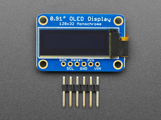 Monochrome OLED module wired to Feather showing text and circles