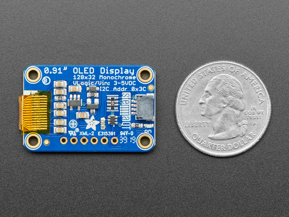 Monochrome OLED module wired to Feather showing text and circles