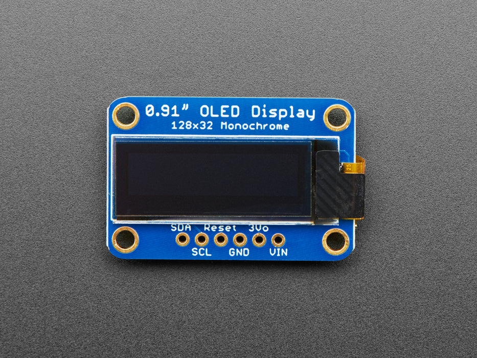 Monochrome OLED module wired to Feather showing text and circles