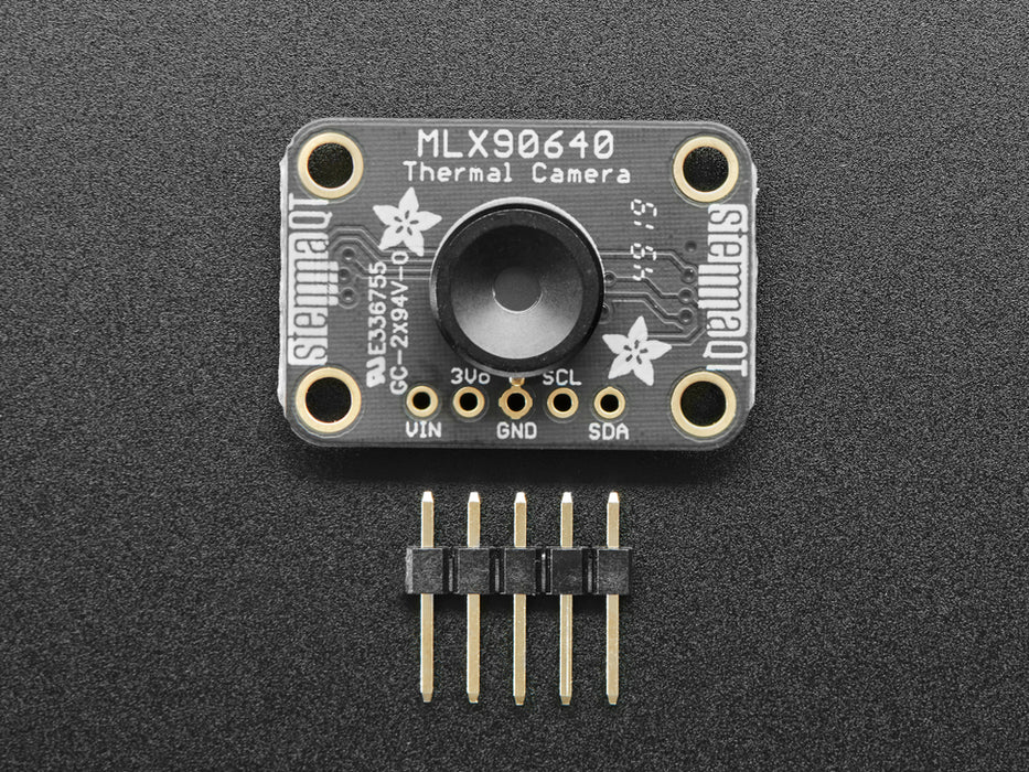 White hand holding and moving around a MLX90640 24x32 IR Thermal Camera Breakout over a Raspberry Pi. The pybadge showing a checker board image of what the camera is seeing. 