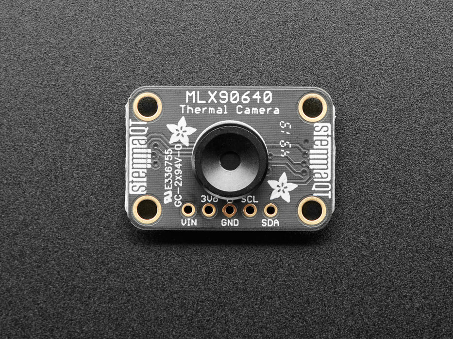 White hand holding and moving around a MLX90640 24x32 IR Thermal Camera Breakout over a Raspberry Pi. The pybadge showing a checker board image of what the camera is seeing. 