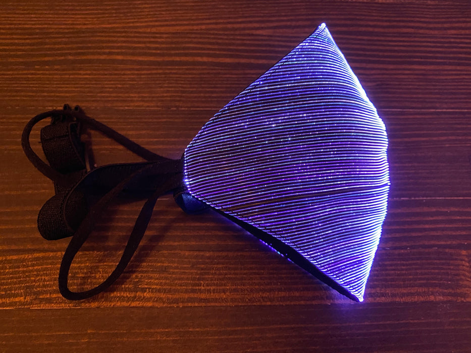 A styrofoam head wearing a black face mask with purple optic fibers.