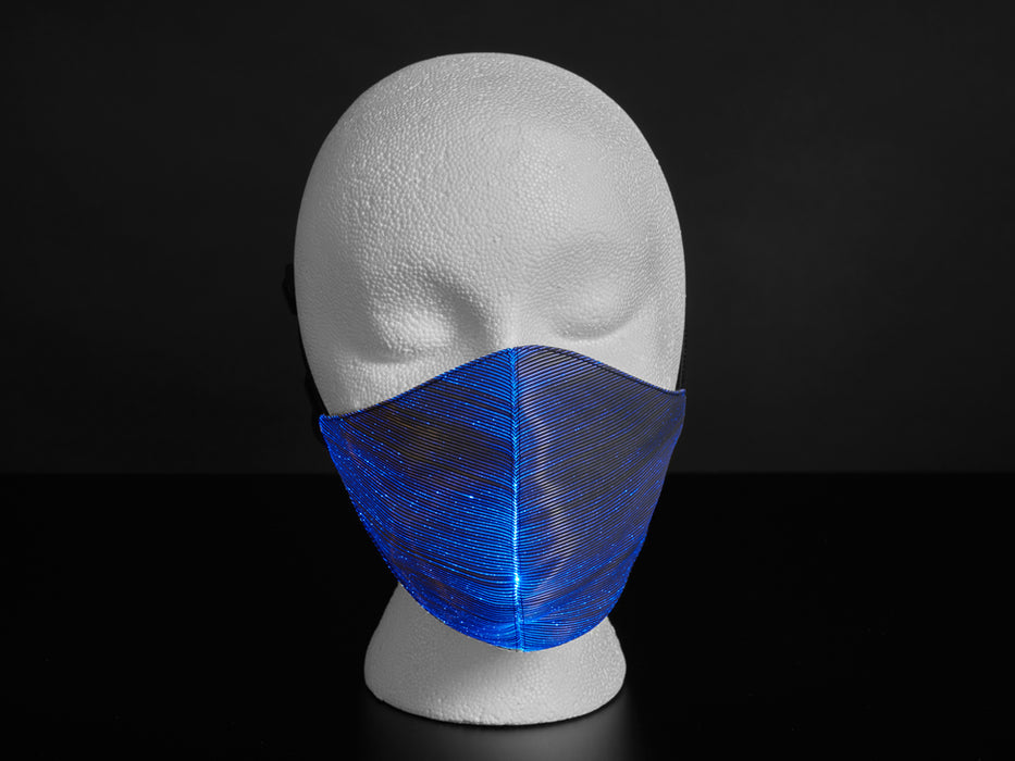 A styrofoam head wearing a black face mask with purple optic fibers.