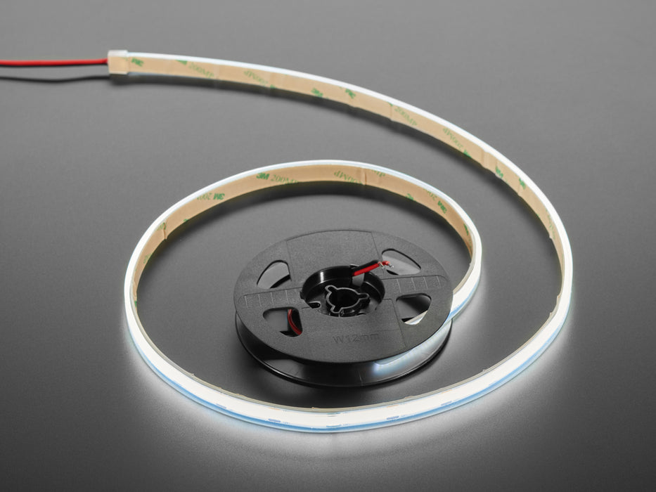 Two hands repeatedly bending and manipulating lit-up bright white flexible LED strip.