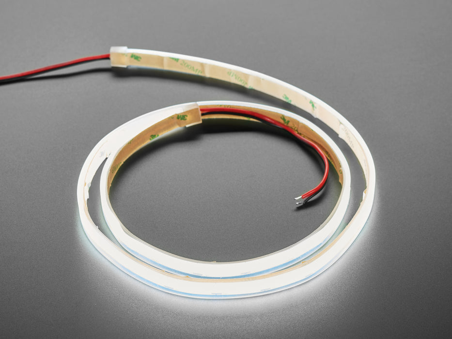 Two hands repeatedly bending and manipulating lit-up bright white flexible LED strip.