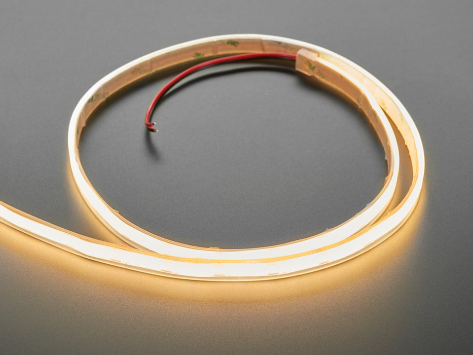 Two hands repeatedly bending and manipulating lit-up flexible warm white LED strip