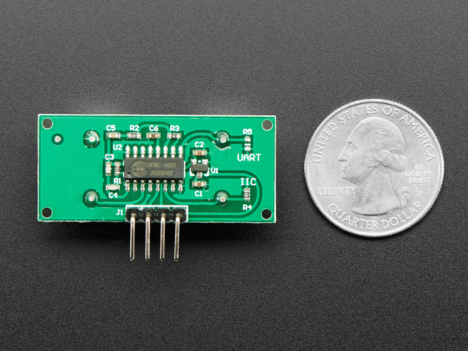 Video of a hand with purple nails hovering over an ultrasonic sensor. The sensor is connected via breadboard to an OLED breakout board, which displays the person's hand's ultrasonic ping distance from the sensor in millimeters.