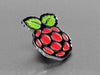 Angled shot of an enamel pin resembling a raspberry