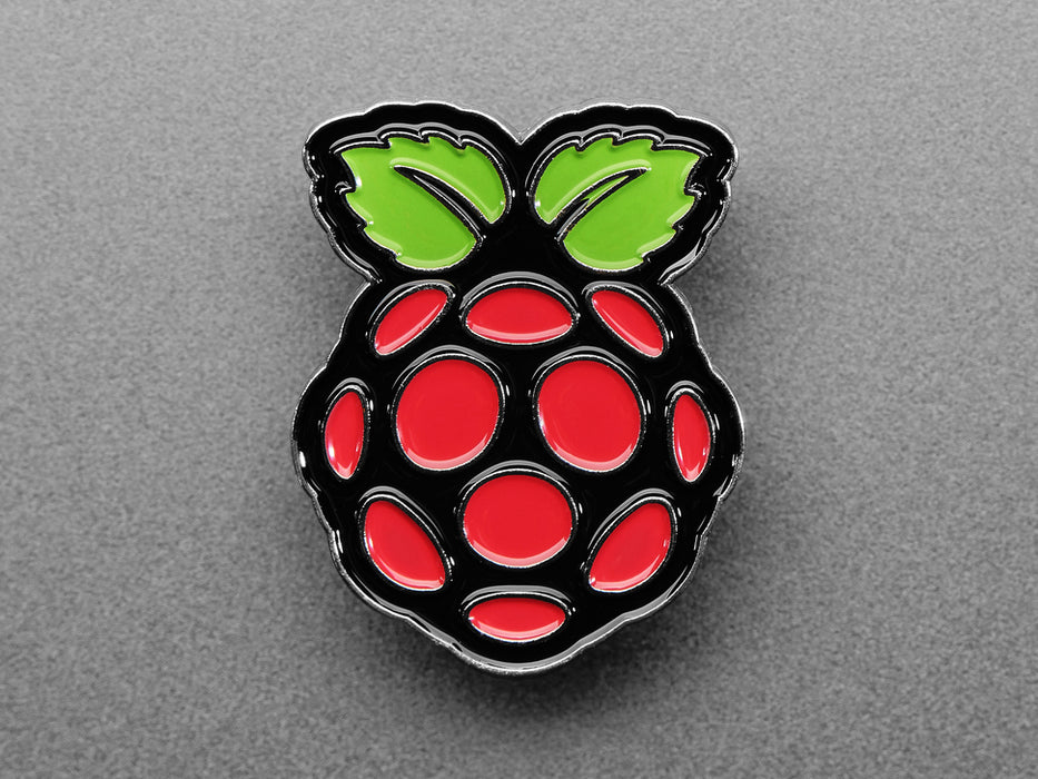 Angled shot of an enamel pin resembling a raspberry