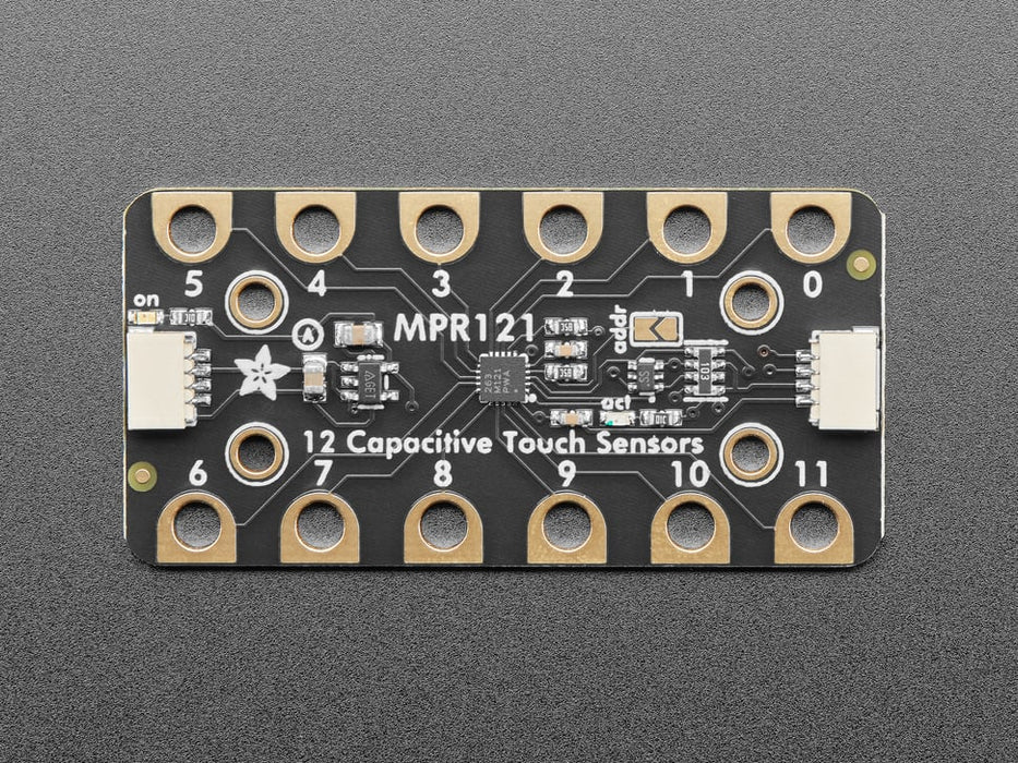 Adafruit MPR121 12-Key Capacitive Touch Sensor Gator Breakout connected to a Feather. A finger presses alligator pads on breakout and OLED displays which pads are touched.