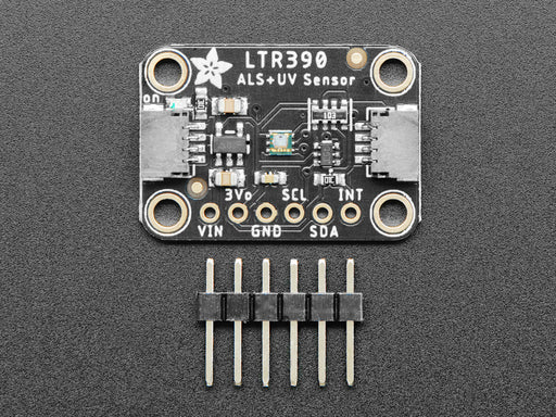 UV lamp swinging over onto sensor, connected to Feather. OLED display shows changing UV and light levels.